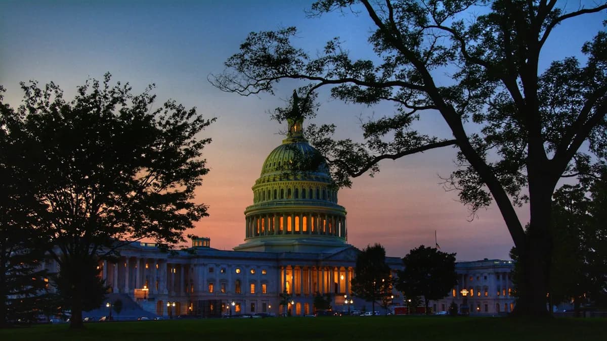 The U.S. Capitol dome lit up at twilight in Washington, DC, seen from the lawn