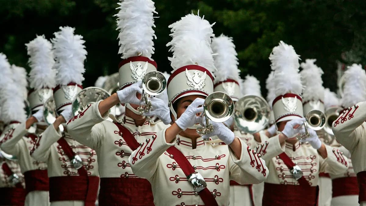 High school marching band in white and red uniforms playing trumpets